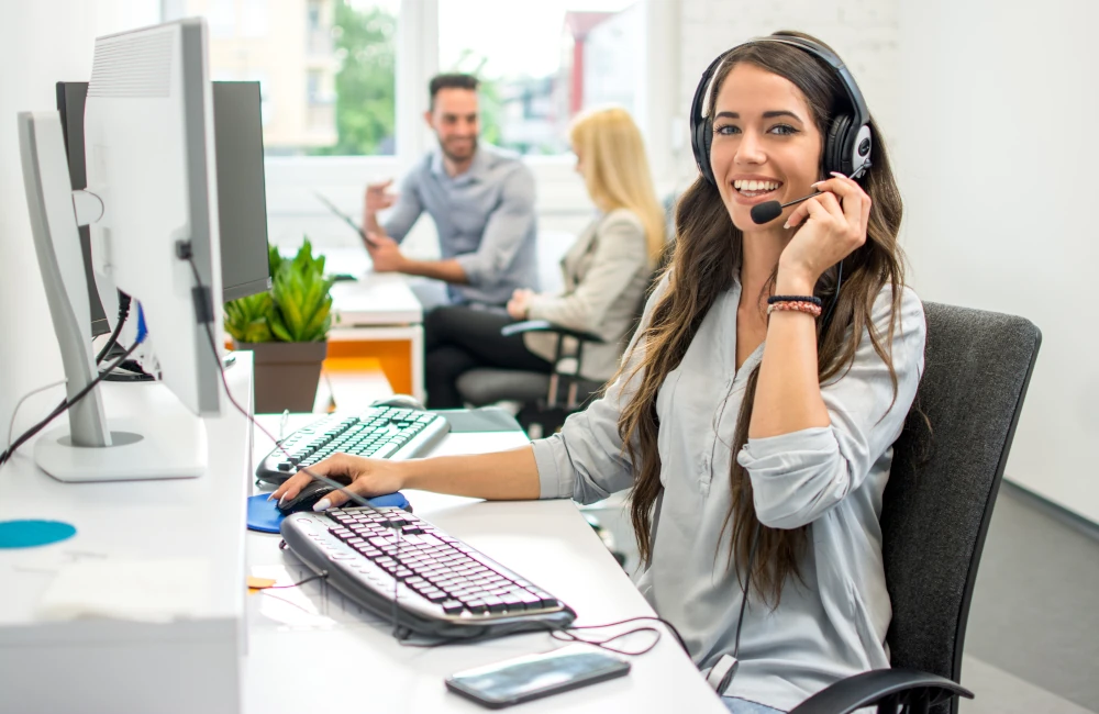 TopBüro Mitarbeiterin mit Headset arbeitet am Rechner