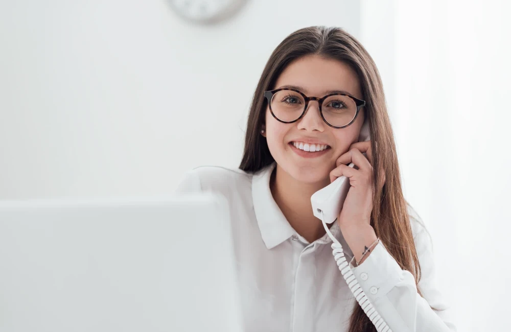 Frau telefoniert und arbeitet am Rechner