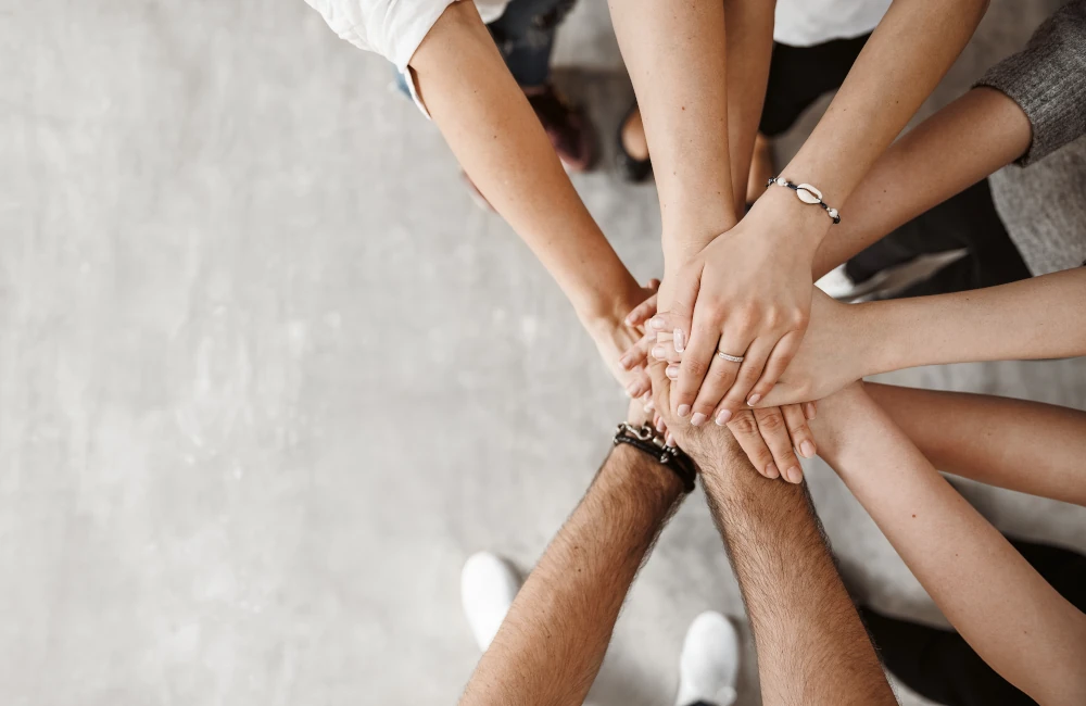 Mehreren Personen die ihre Hände übereinander legen