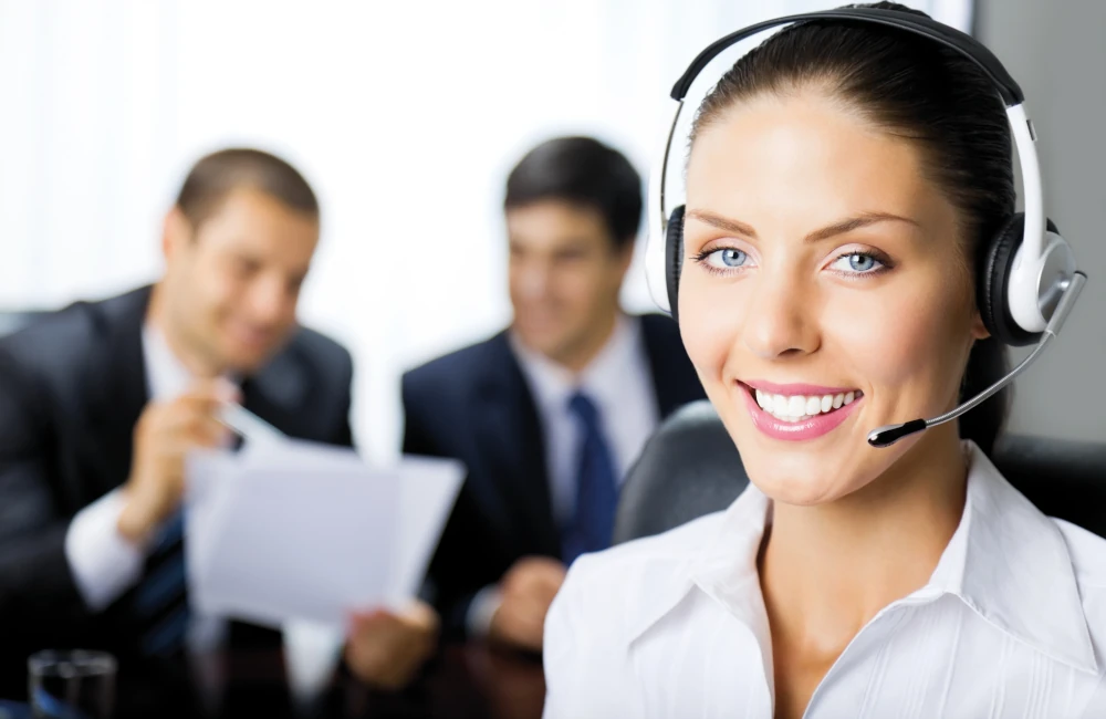 TopBüro Mitarbeiterin mit Headset arbeitet am Rechner