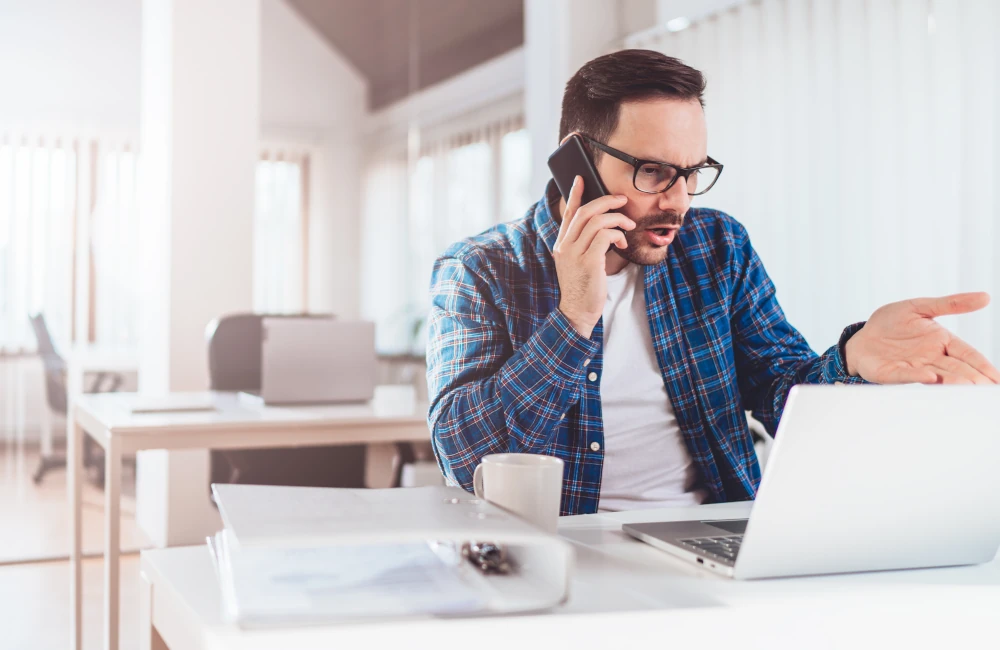 Gestresster Büroarbeiter am Telefon
